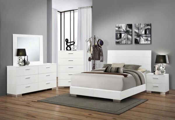 Modern bedroom with white furniture and decor.