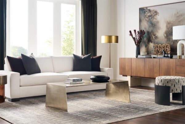 Modern living room with white sofa and gold accents.